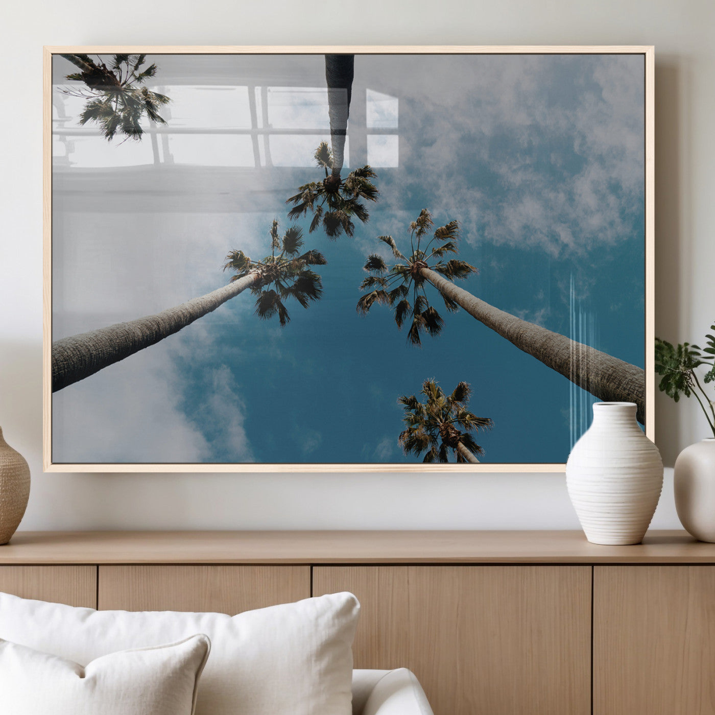 Looking up at tall palm trees against a bright blue sky with scattered clouds, creating a tropical and airy atmosphere for modern home decor.