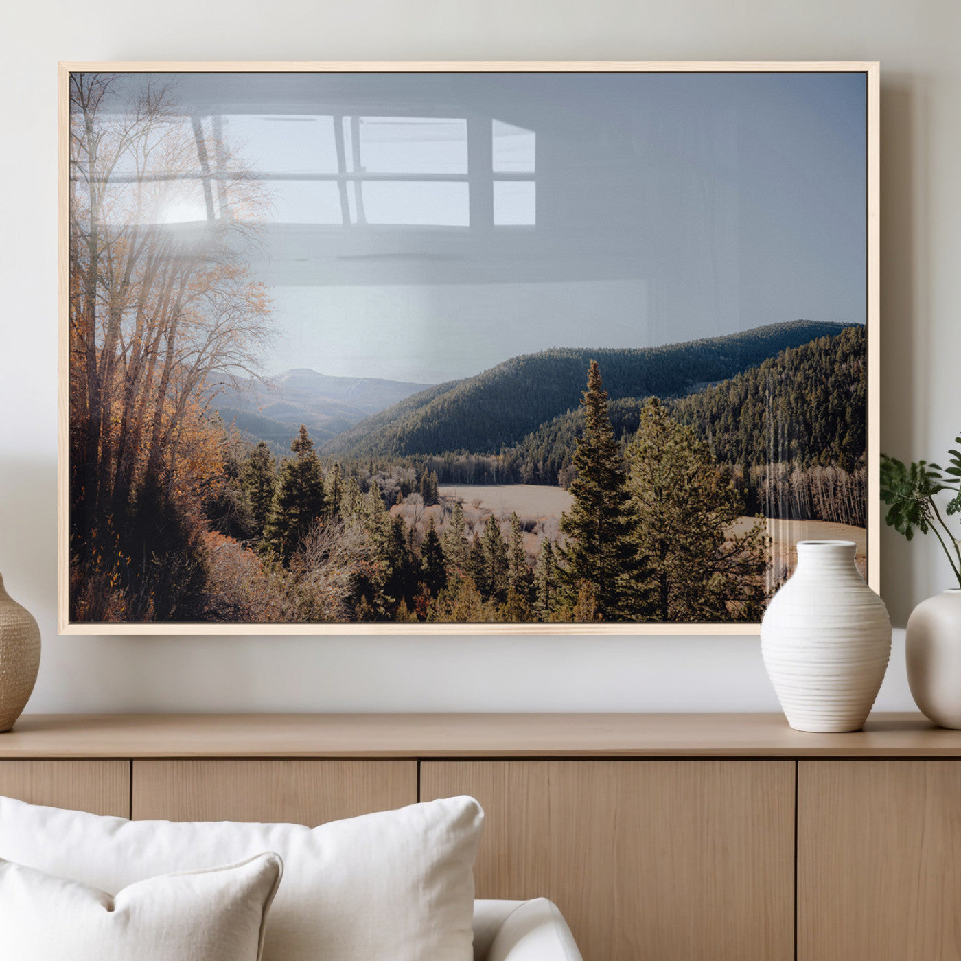 A scenic mountain valley with pine trees and autumn foliage under a clear sky, bathed in golden sunlight, creating a peaceful and rustic landscape.