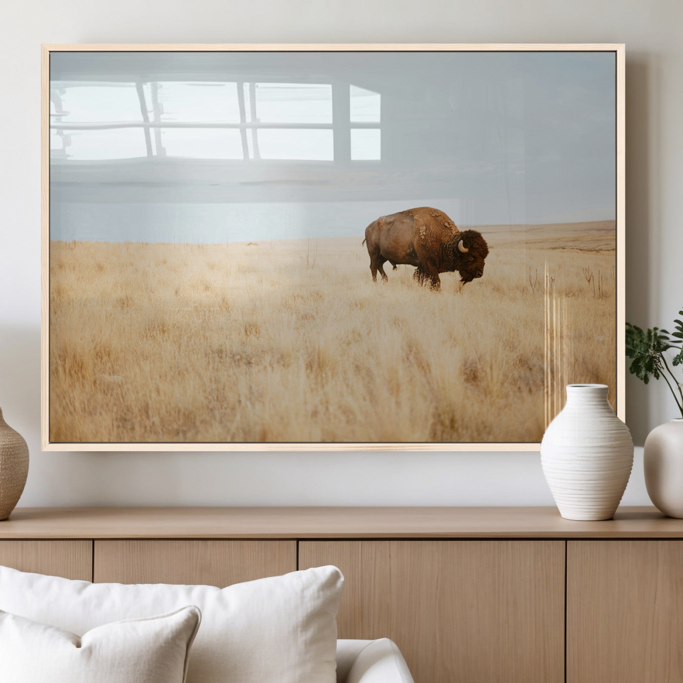 A lone bison standing in a vast golden grassland under a soft blue sky, evoking a rustic and Western aesthetic, ideal for farmhouse decor.