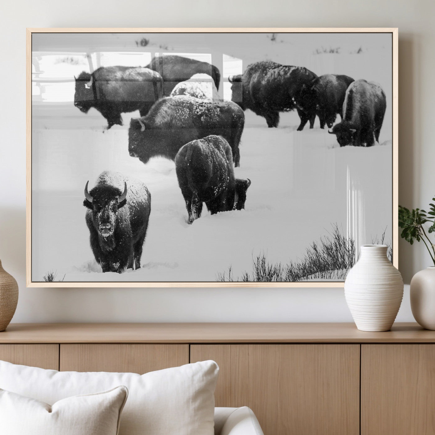 Black and white photograph of a bison herd in a snowy landscape, with snow-covered fur and a rugged wilderness setting, perfect for rustic lodge decor.