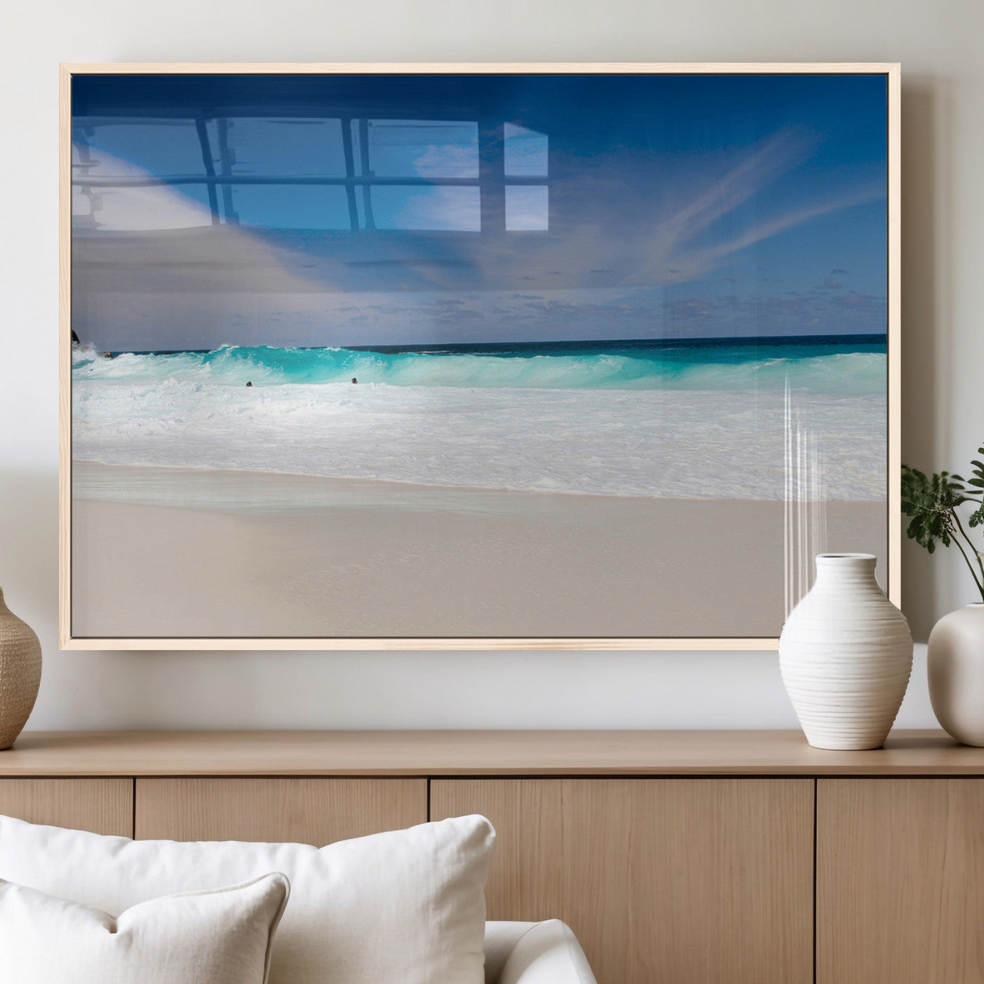 Turquoise waves crash onto a pristine white sand beach under a vivid blue sky with wispy clouds, creating a peaceful and refreshing coastal scene.