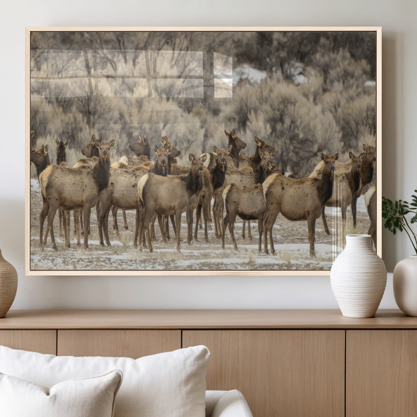 A stunning wall art canvas print featuring a large herd of elk standing together in a natural winter landscape with muted earthy tones and soft background foliage, perfect for rustic or nature-inspired home decor.