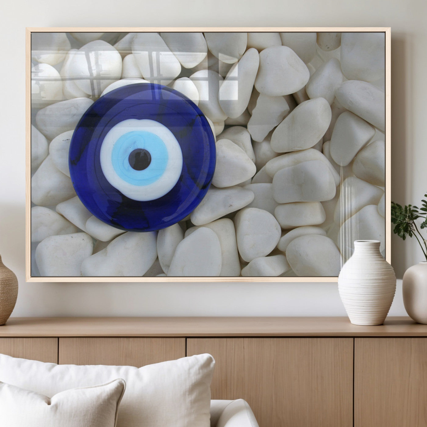A close-up of a blue evil eye charm placed on white pebbles, symbolizing protection and good luck.