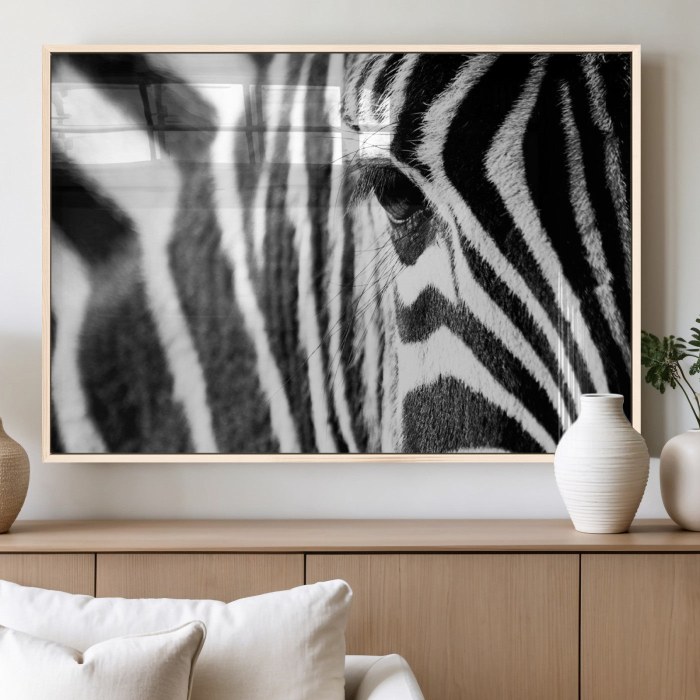 A close-up black and white photograph of a zebra's eye, showcasing the intricate patterns of its stripes in sharp detail.