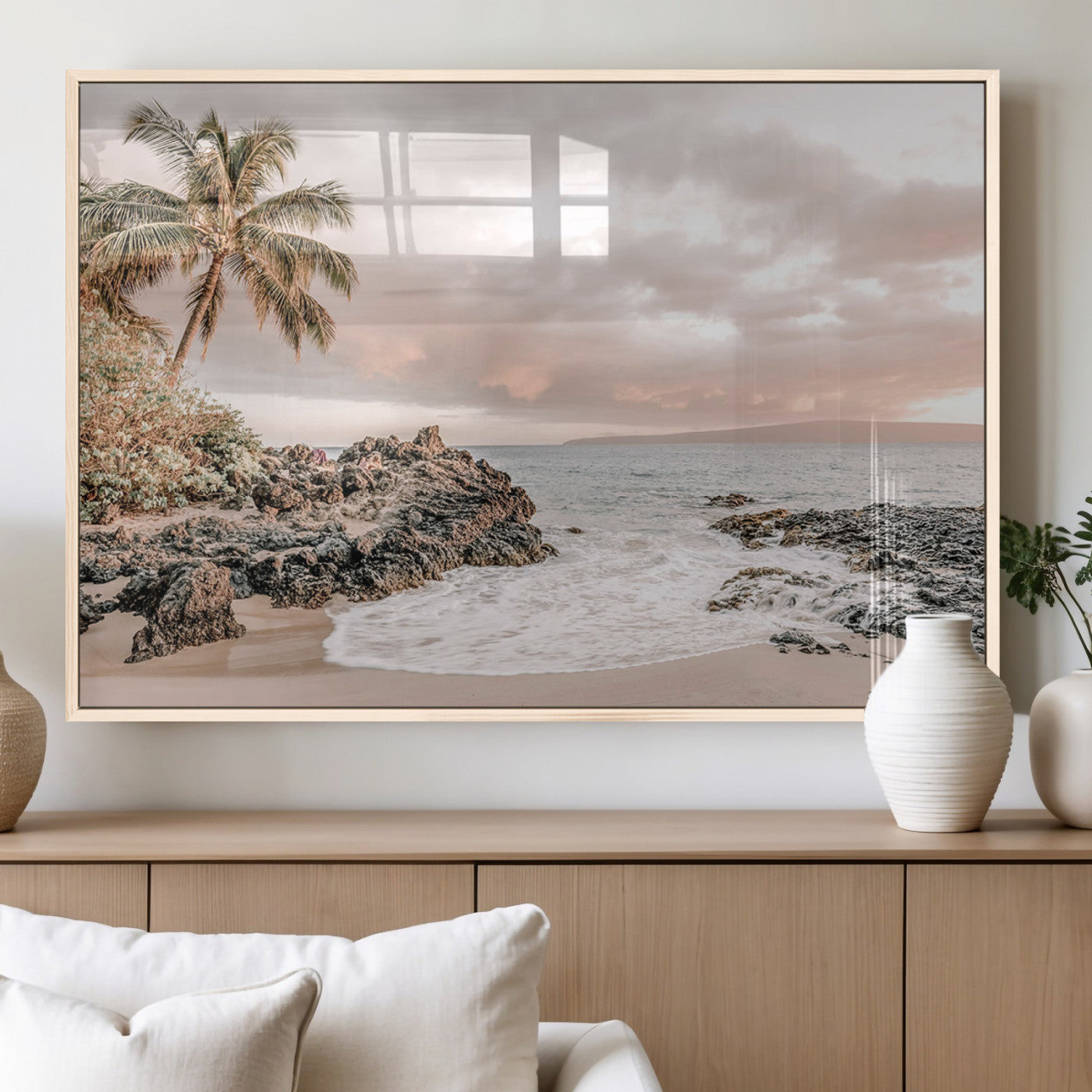 A peaceful beach scene with a palm tree and rocks, soft waves washing onto the shore under a soft pastel sky at sunset.