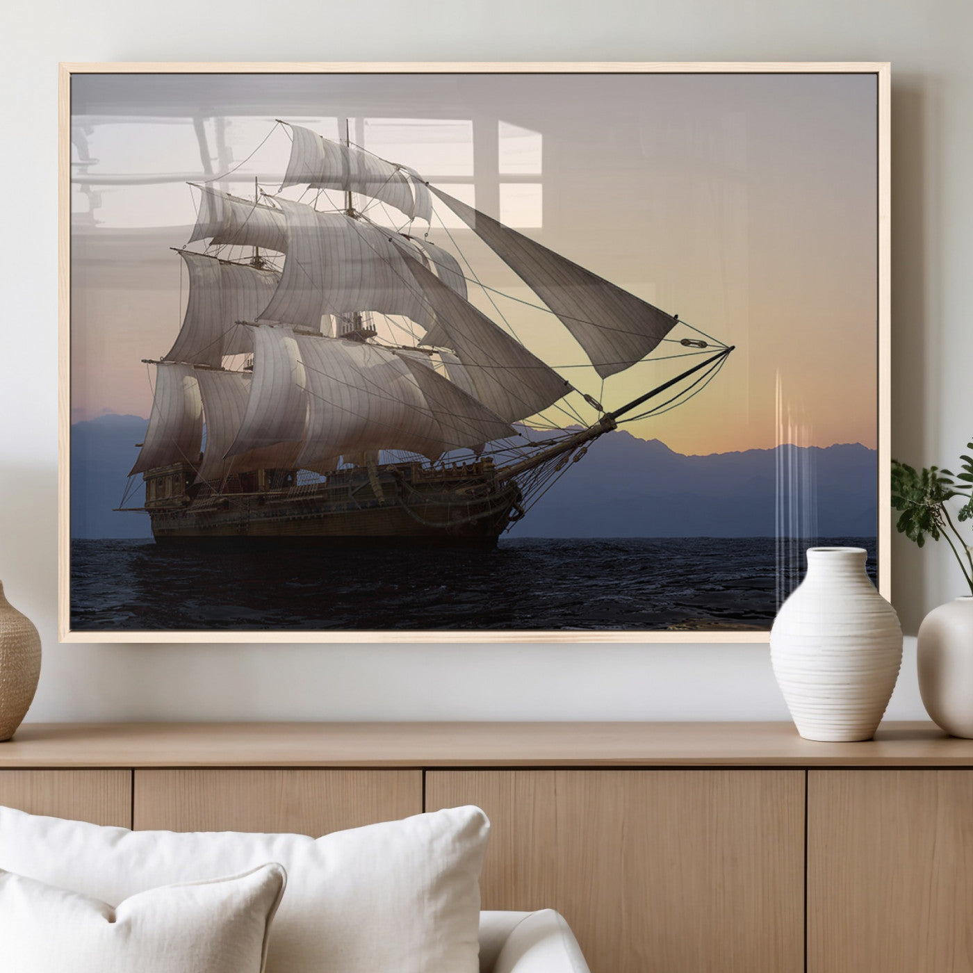Majestic tall ship with full sails gliding across the ocean at sunset, with mountain silhouettes in the background – Wall Art Canvas Print.