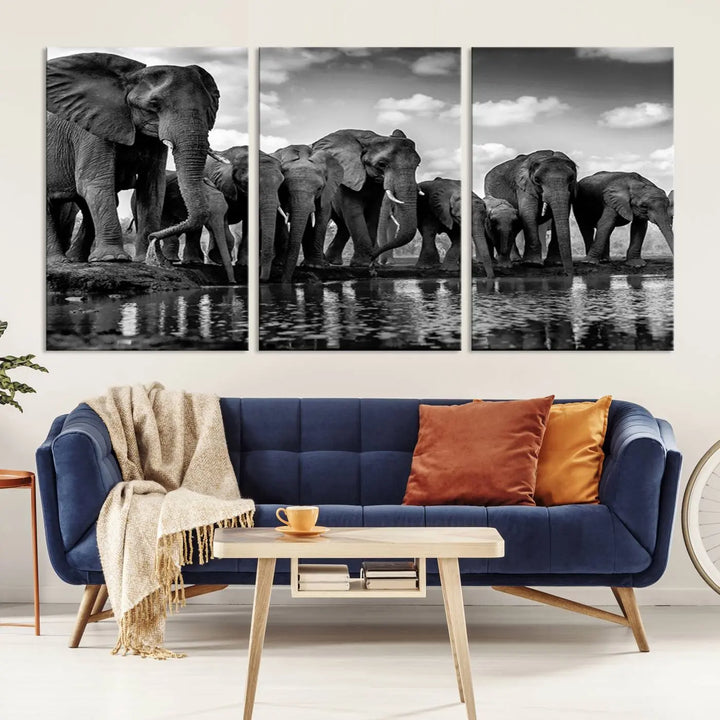 A stunning "Wall Art Animal Canvas Print" featuring a black and white photo of a herd of elephants drinking water is elegantly displayed, gallery wrapped on museum-quality canvas.