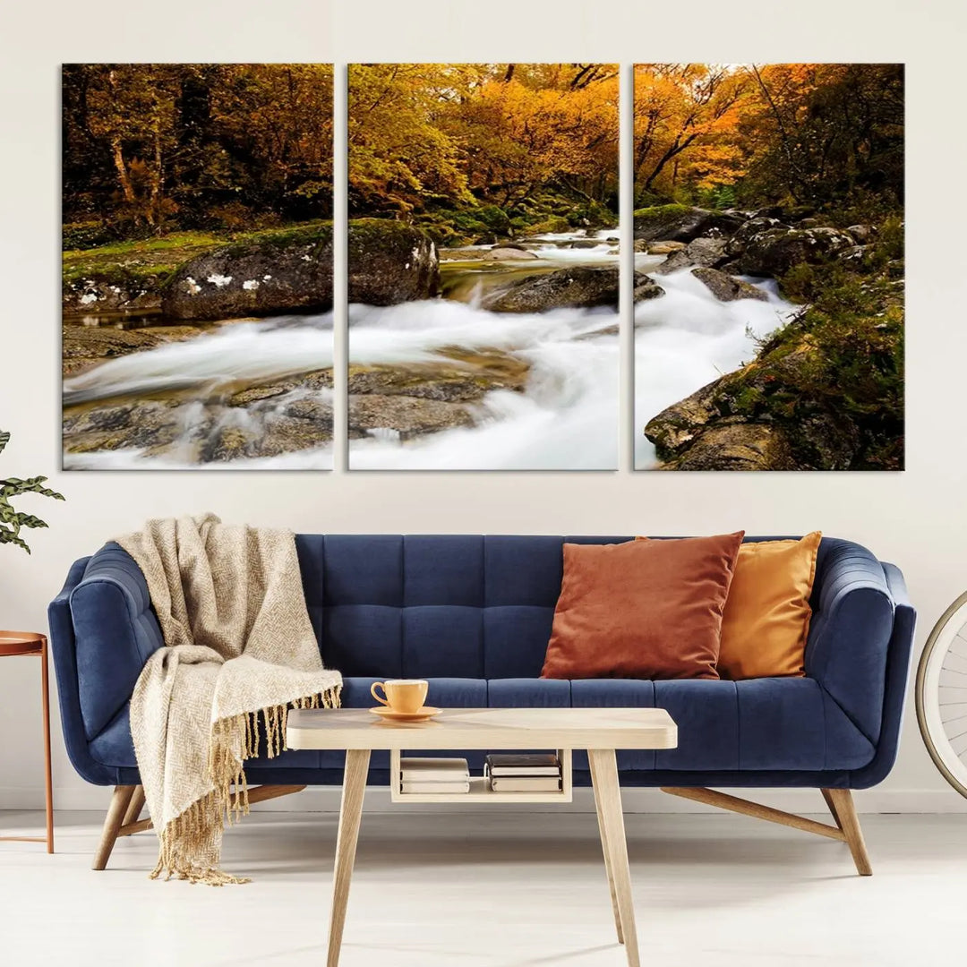 The living room is adorned with the "Wall Art Waterfall Canvas Print River in Forest in Autumn," a triptych on museum-quality canvas showcasing a flowing river surrounded by autumn trees. This ready-to-hang artwork features a UV-protective coating to ensure enduring vibrancy.