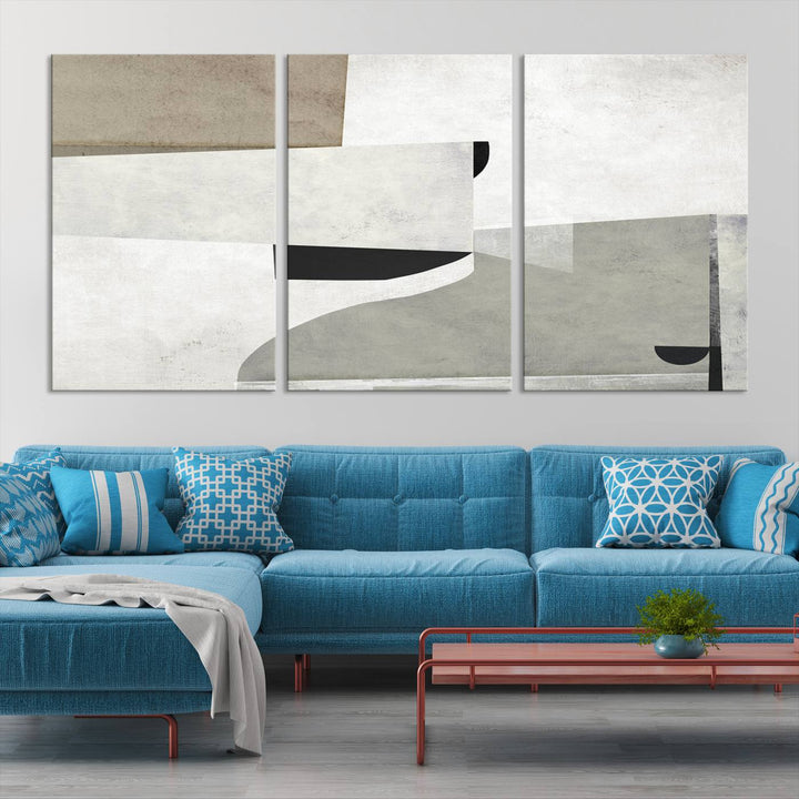 The Brown Gray Figures Abstract Wall Art Canvas Print is displayed as a triptych on a dark wall. The piece is gallery wrapped, offering a seamless finish and enhanced durability due to its UV-protective coating.