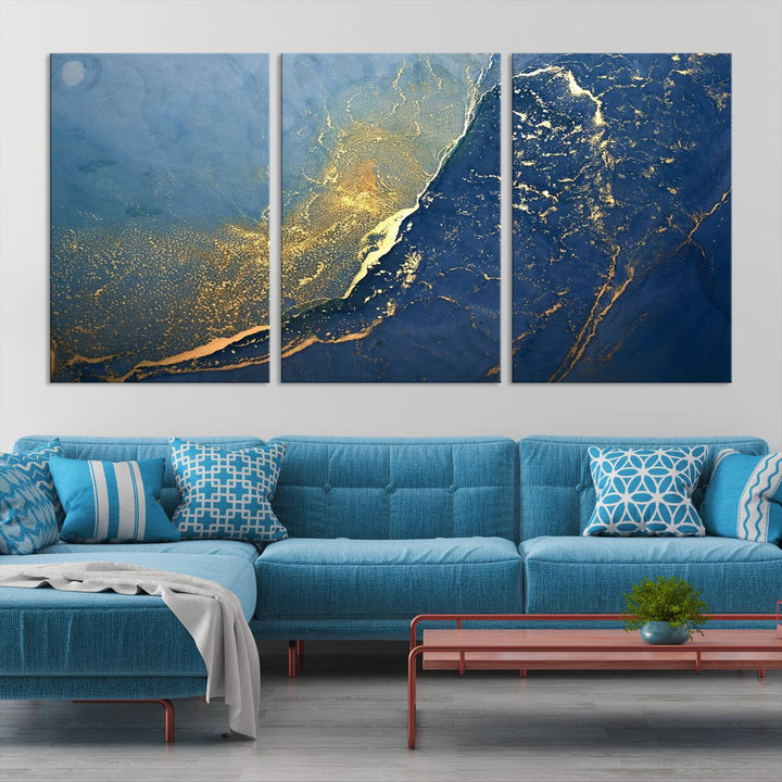 The Navy Blue Yellow Twinkle Wall Art Canvas Print, featuring an abstract design in gold and blue, enhances a modern living room as it adorns a white wall with its gallery-wrapped, museum-quality canvases for an exquisite touch.