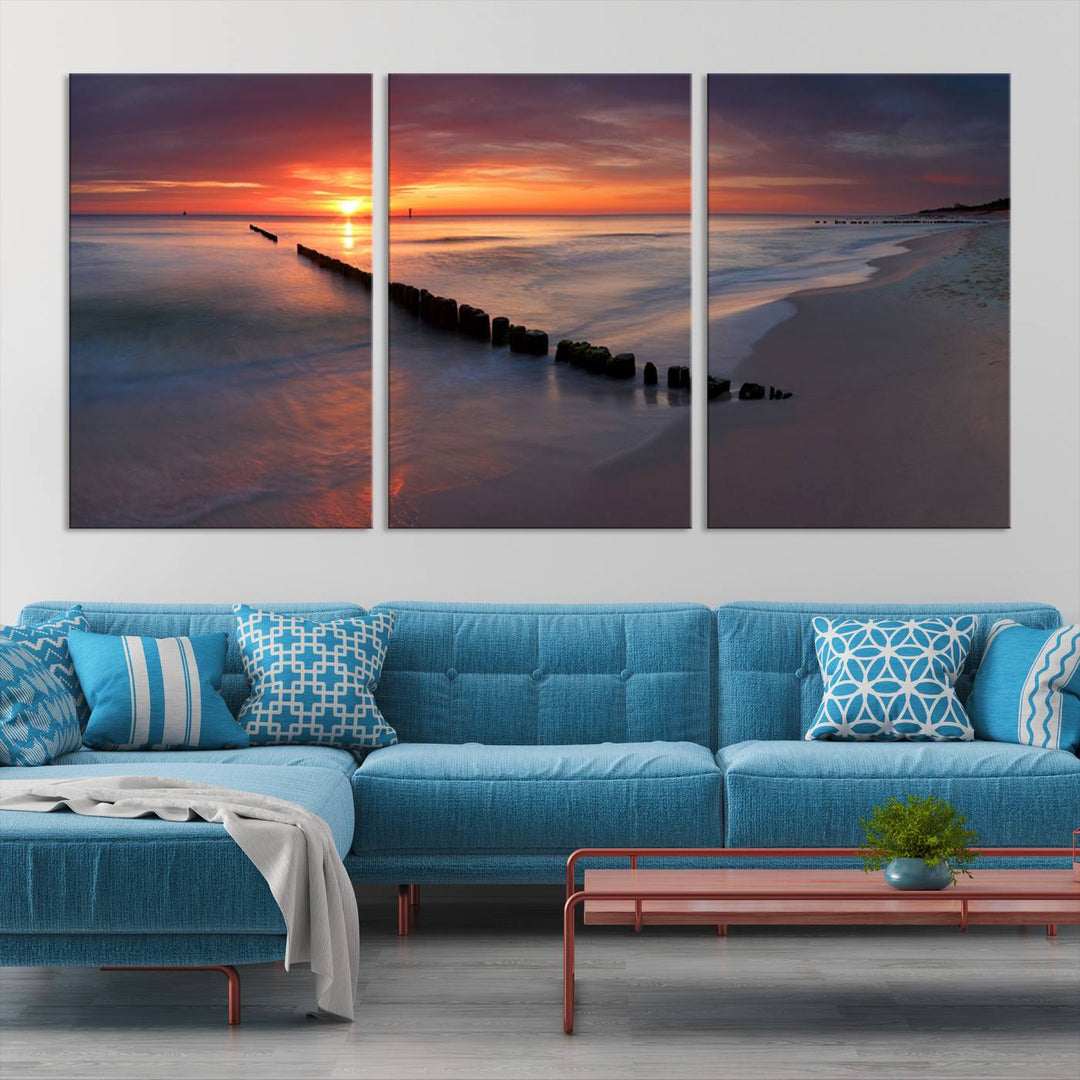 In a modern living room, the Sunset Beach Wall Art Canvas Print is displayed above. This triptych, printed on museum-quality canvas with a UV-protective coating, ensures lasting brilliance. It's ready to hang and brings an elegant touch to your space.