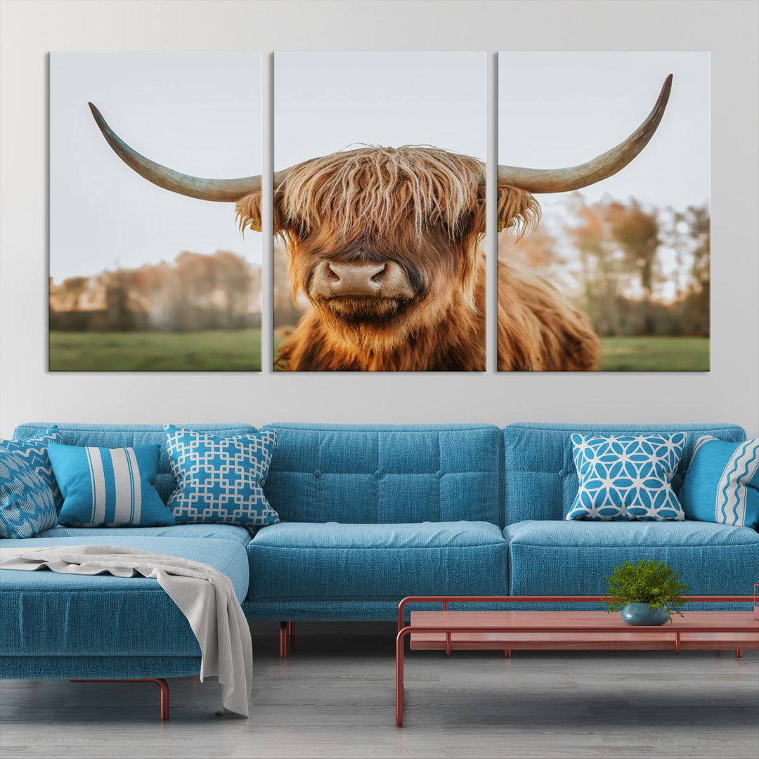 A Highland Cow Animal Scottish Cattle Art Print Farmhouse Wall Art Canvas Print hangs in the living room, adding a touch of rustic farmhouse decor.