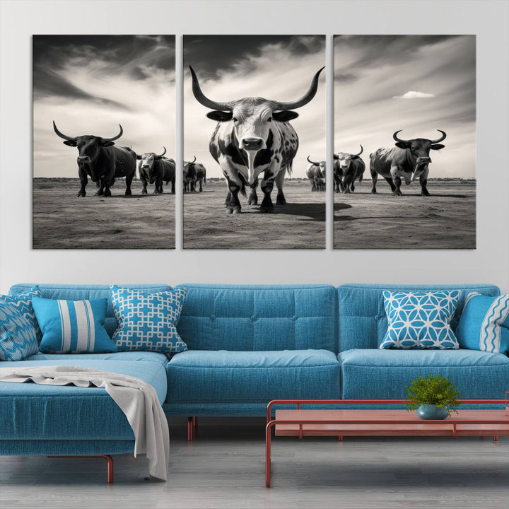 The Black and White Longhorn Cattle Wall Art, featuring a three-panel display of cowboy Western longhorns walking toward the viewer, enhances your space with its striking presence, adding a touch of Western decor.