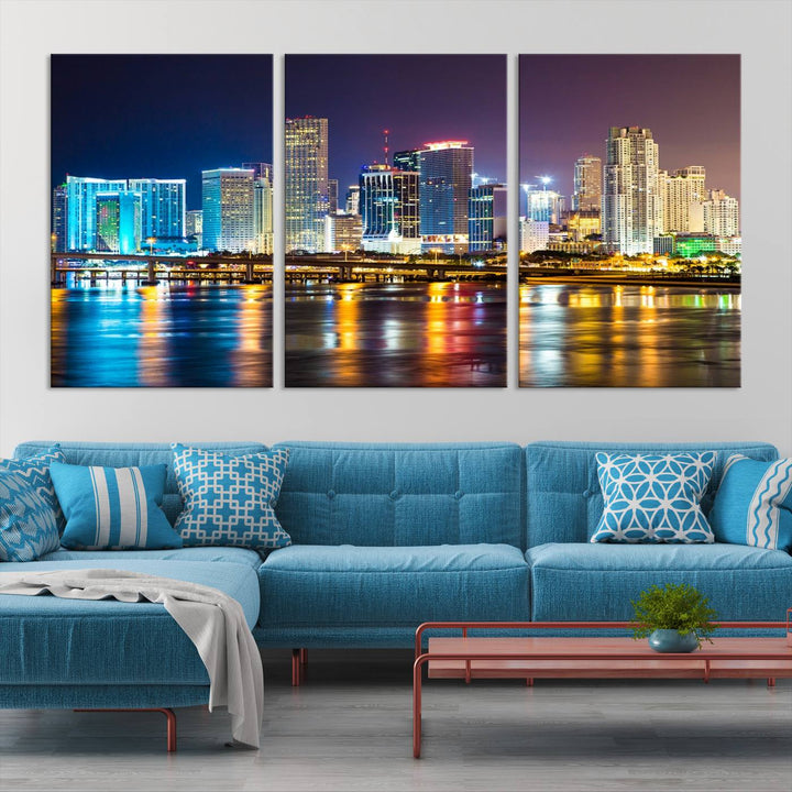 The Wall Art MIAMI Canvas Print features a stunning triptych of a city skyline at night, with vibrant lights reflecting on the water. This gallery-wrapped piece on museum-quality canvas delivers an exquisite finish.