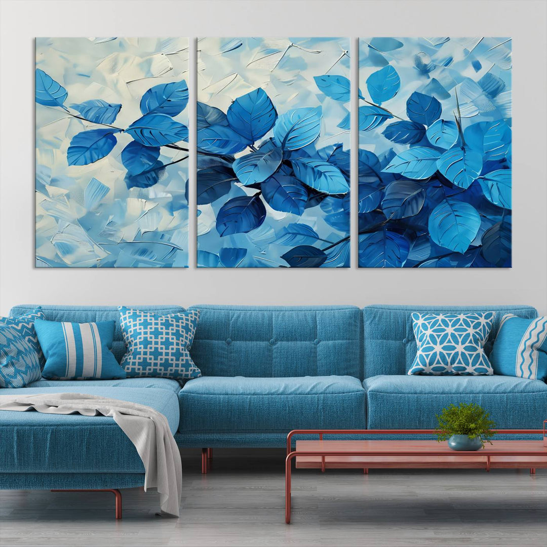 The contemporary living room is highlighted by the Abstract Blue Leaf Wall Art Canvas Print on the wall. The hand-assembled framed art enhances the room's vibrant decor, crafting a gallery-worthy ambience.