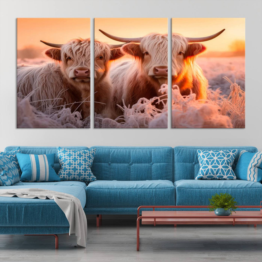 The "Highland Cows at Sunrise Wall Art Canvas Set" beautifully captures a serene and rustic farmhouse aesthetic, portraying two Highland cows in a frosty landscape at sunrise.