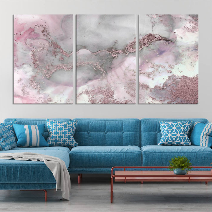 The Rose Marble Abstract Wall Art Canvas Print is a stunning triptych that showcases pink and gray tones, elegantly presented on a dark wall.