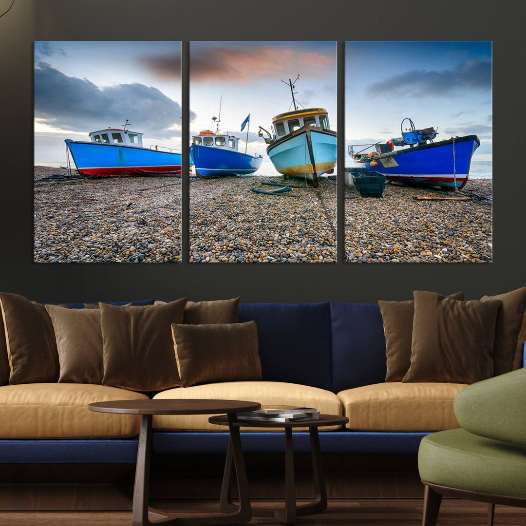 The "Big Boats On The Beach Wall Art Canvas Print" is a stunning piece featuring three museum-quality panels depicting fishing boats on a pebbled shore. Ready to hang and featuring UV-protective coating, it serves as an elegant addition to your home décor.