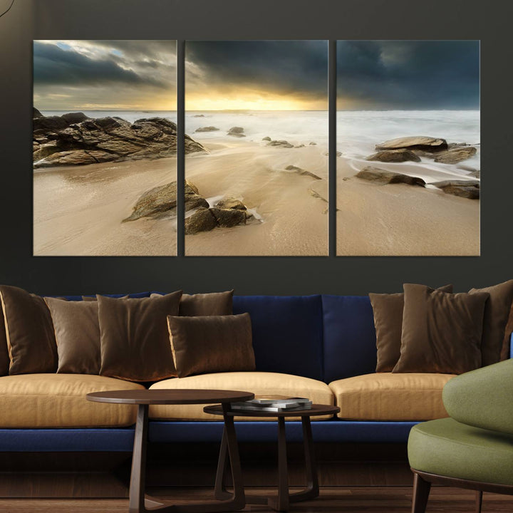 A gallery-wrapped, three-panel artwork titled "Rocks and Waves Wall Art Canvas Print" depicts a rocky beach at sunset. Each canvas showcases museum-quality craftsmanship and a UV-protective coating to maintain its vibrant colors.