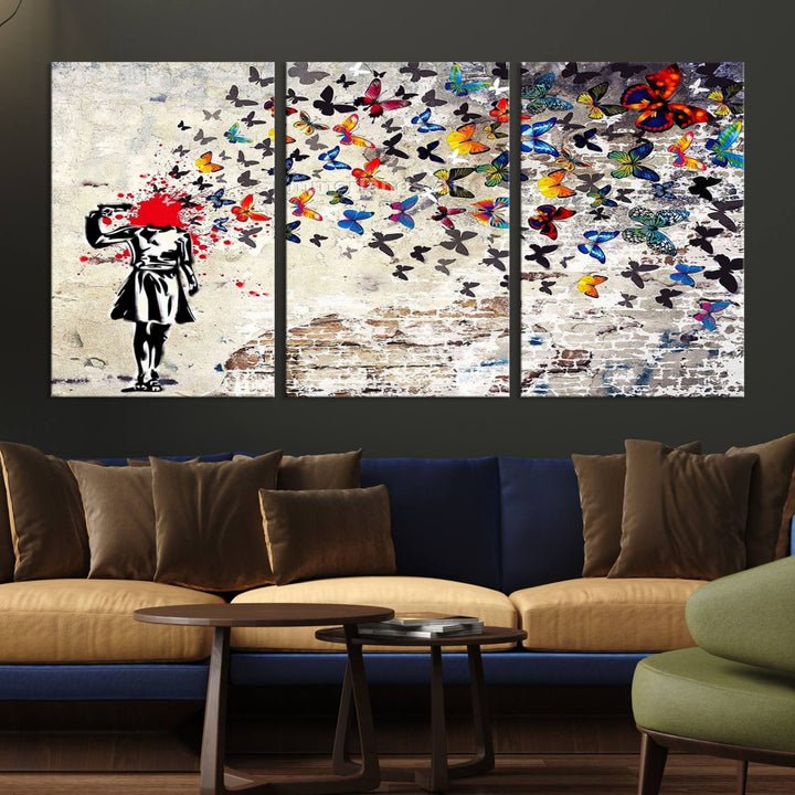 The Banksy Art Butterfly Girl Explosion Canvas showcases a dynamic figure with butterflies bursting from their head, set against a textured wall background. This vibrant urban graffiti piece is perfect for modern interiors and comes ready to hang.