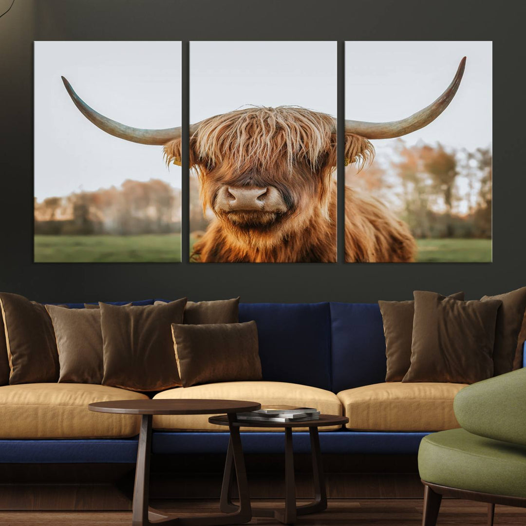 A Highland Cow Animal Scottish Cattle Art Print Farmhouse Wall Art Canvas Print hangs in the living room, adding a touch of rustic farmhouse decor.