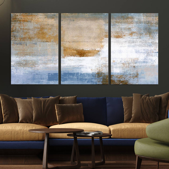 The Blue Multi Panel Abstract Wall Art Canvas Print, featuring an elegant blend of blue, beige, and brown tones, hangs gracefully on the wall, adding a contemporary touch to the space.