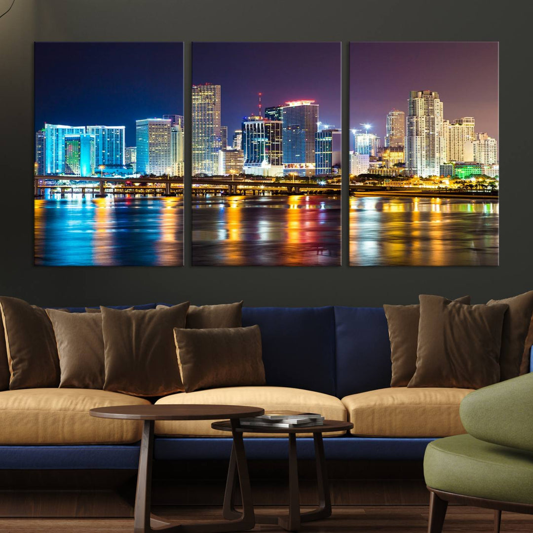 The Wall Art MIAMI Canvas Print features a stunning triptych of a city skyline at night, with vibrant lights reflecting on the water. This gallery-wrapped piece on museum-quality canvas delivers an exquisite finish.