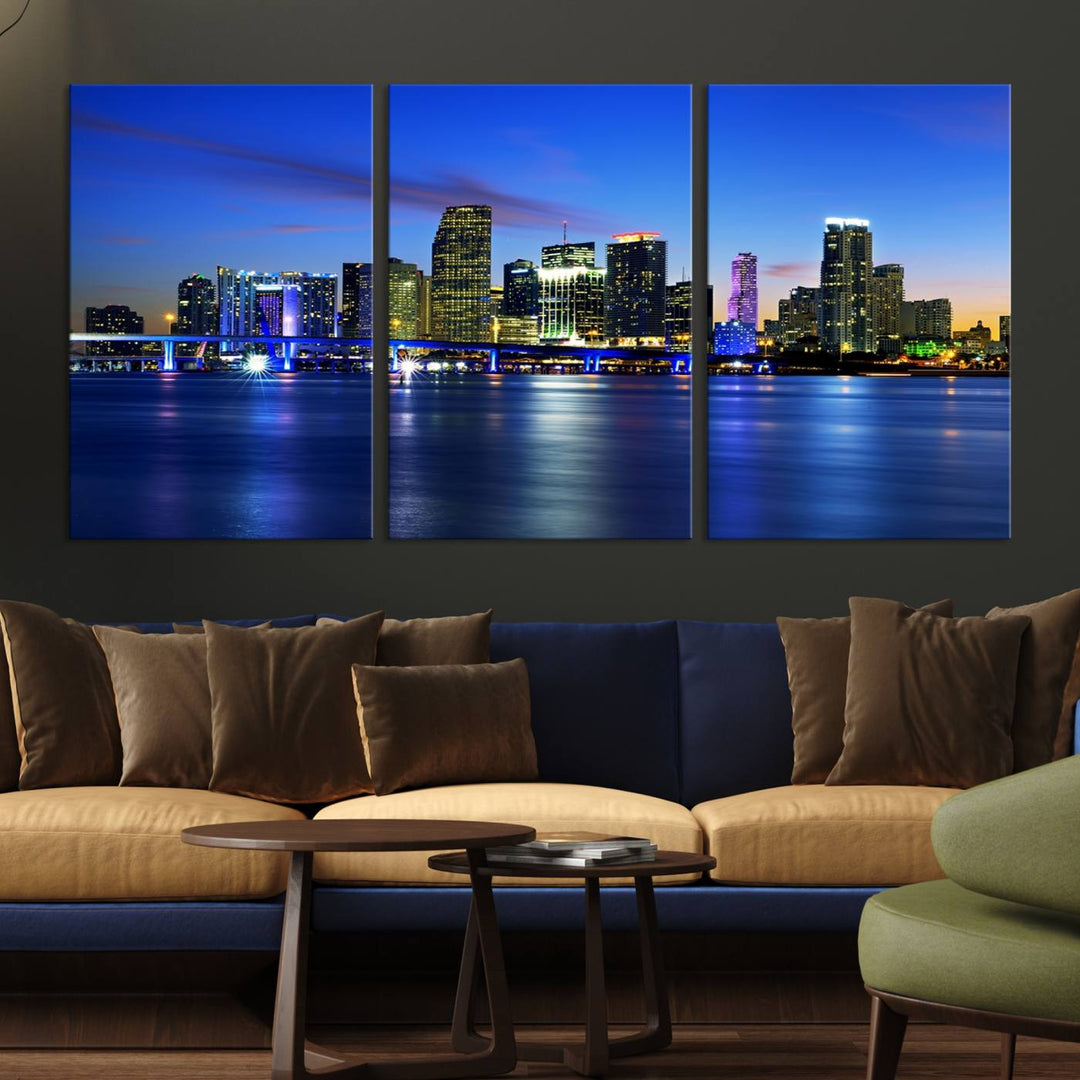 The modern living room showcases a striking Miami Blue Night Wall Art canvas print on the wall. The artwork is gallery wrapped on museum-quality canvas, ensuring durability and elegance.