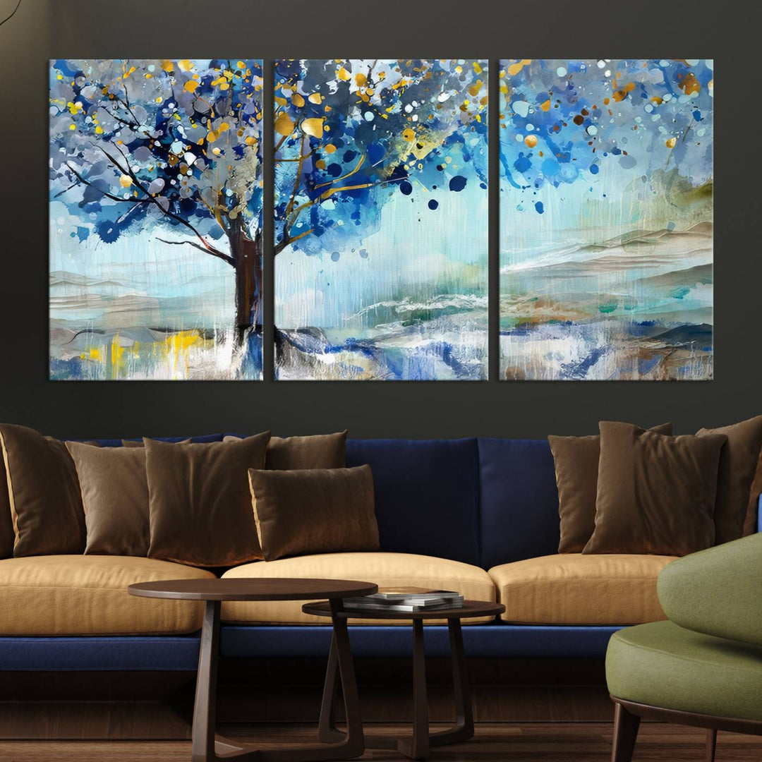 A modern living room features a three-panel Watercolor Style Abstract Tree Printing Wall Art Canvas in vibrant blue and yellow, crafted on museum-quality material.