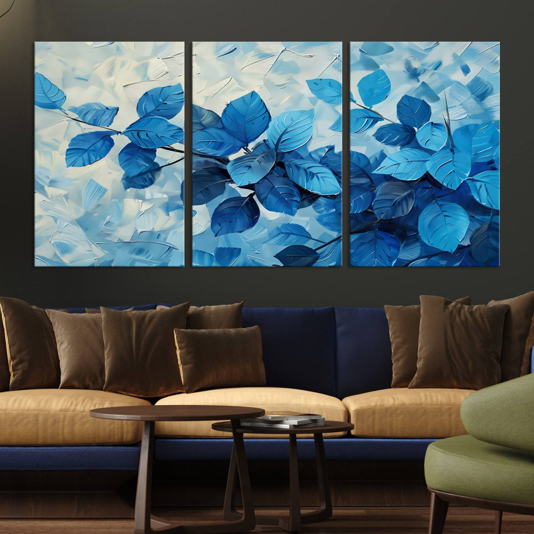 The contemporary living room is highlighted by the Abstract Blue Leaf Wall Art Canvas Print on the wall. The hand-assembled framed art enhances the room's vibrant decor, crafting a gallery-worthy ambience.