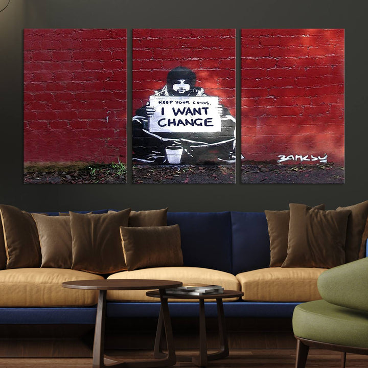 The living room showcases a triptych of stencil artwork on museum-quality canvas, featuring the Banksy I Want Change Graffiti Abstract Wall Art Canvas Print. This captivating piece depicts a person holding a sign that says "I want change" and is finished with a UV-protective coating to ensure long-lasting beauty.