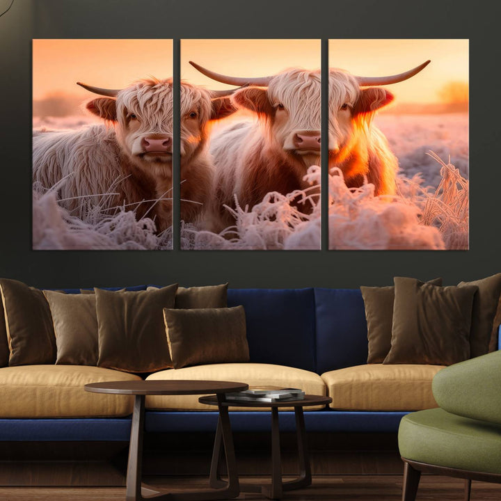 The "Highland Cows at Sunrise Wall Art Canvas Set" beautifully captures a serene and rustic farmhouse aesthetic, portraying two Highland cows in a frosty landscape at sunrise.