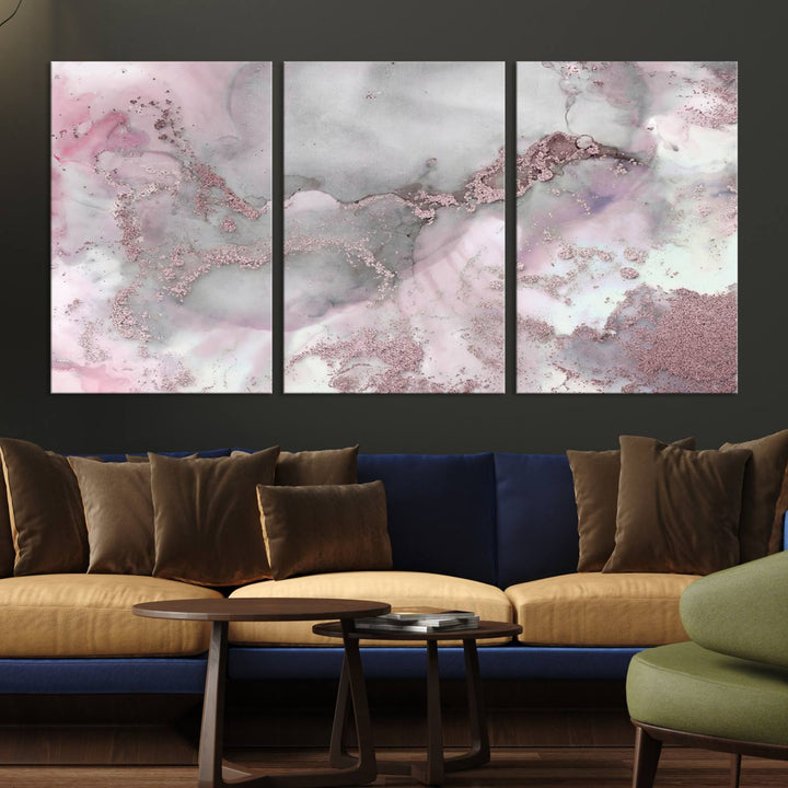 The Rose Marble Abstract Wall Art Canvas Print is a stunning triptych that showcases pink and gray tones, elegantly presented on a dark wall.