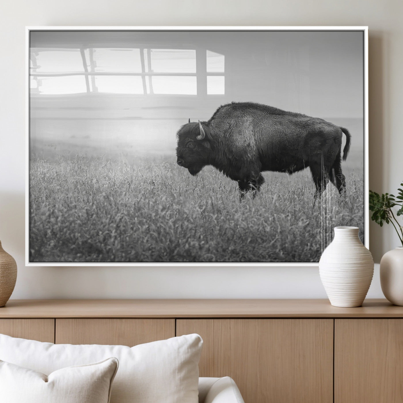 A black and white photograph of a majestic bison standing in a vast grassy prairie, evoking a sense of wilderness and strength.