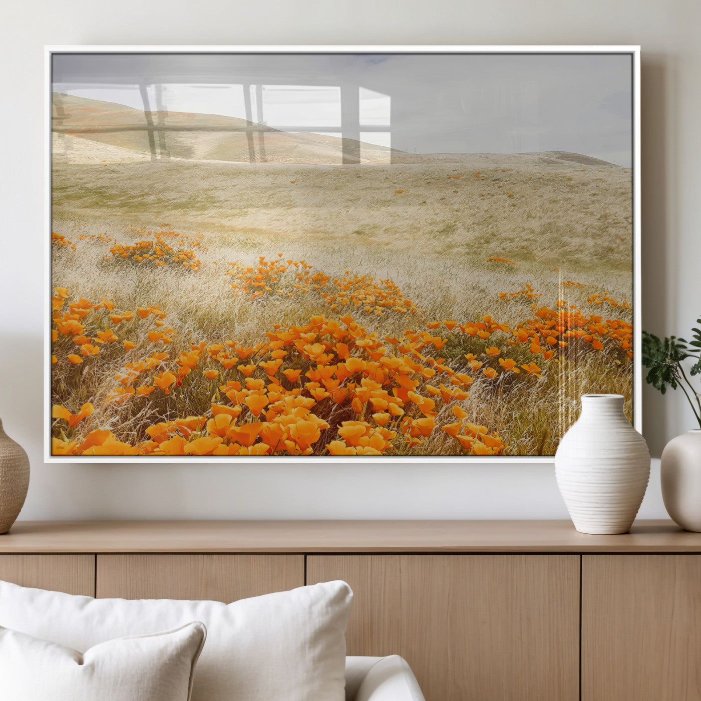 A golden field with vibrant orange poppies blooming across rolling hills under a soft, sunlit sky, creating a warm and rustic landscape.