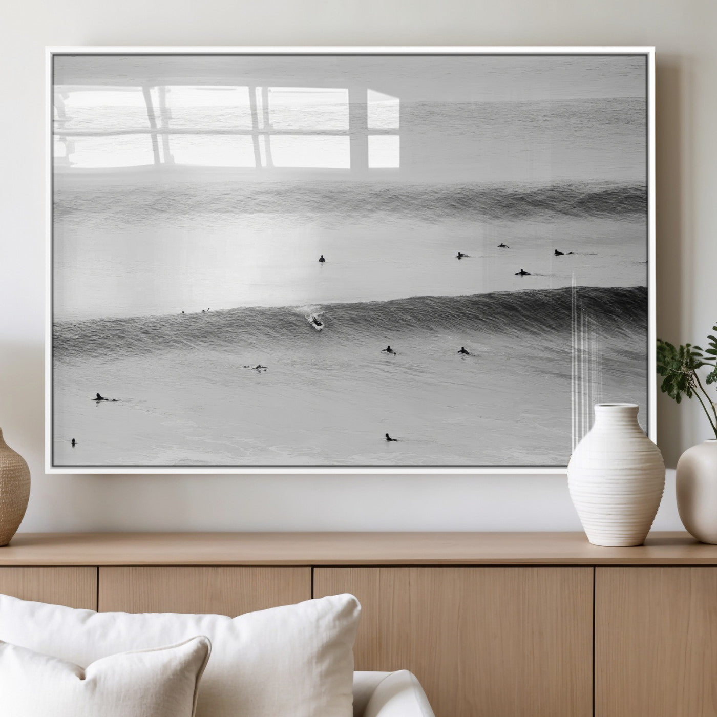 A monochrome photograph of swimmers gliding through gentle ocean waves, evoking a sense of calm and movement.