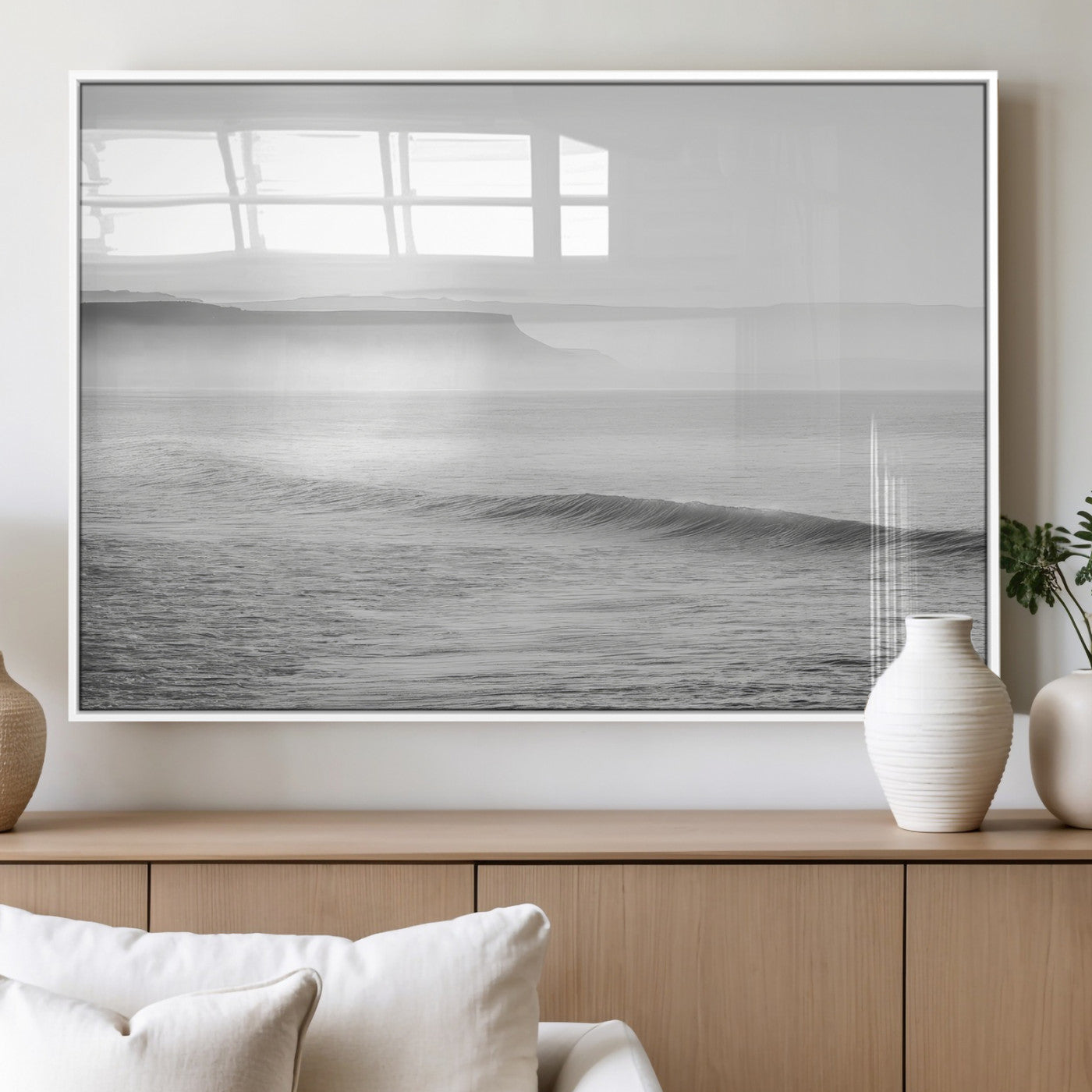 A black and white minimalist seascape featuring soft rolling waves and misty distant cliffs, creating a serene and timeless coastal atmosphere.
