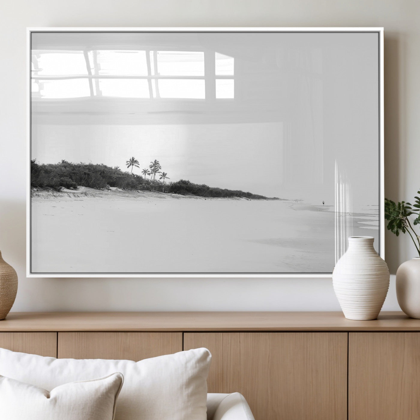 A black and white minimalist coastal scene with a vast open beach, distant palm trees, and a lone figure walking along the shoreline, evoking serenity and solitude.