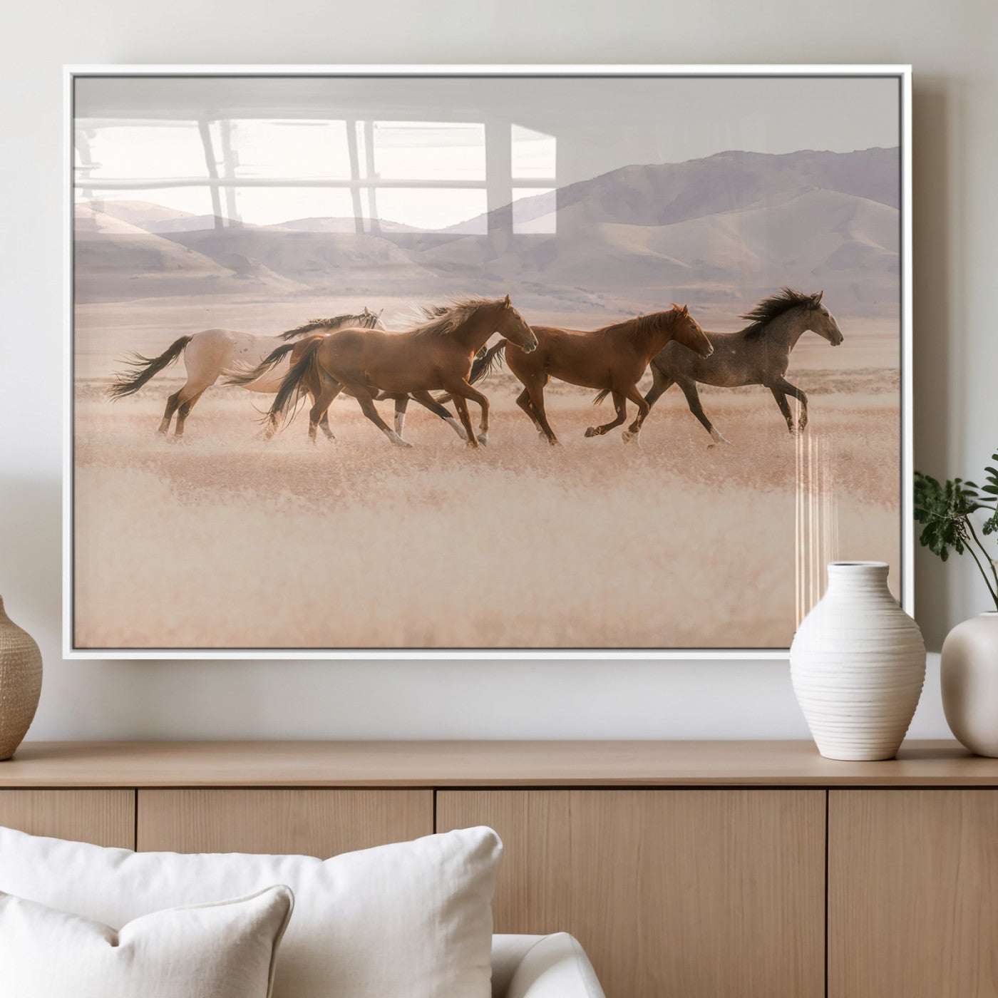 A herd of wild horses galloping through a sunlit desert plain with mountains in the background, perfect for rustic or western-themed wall decor.