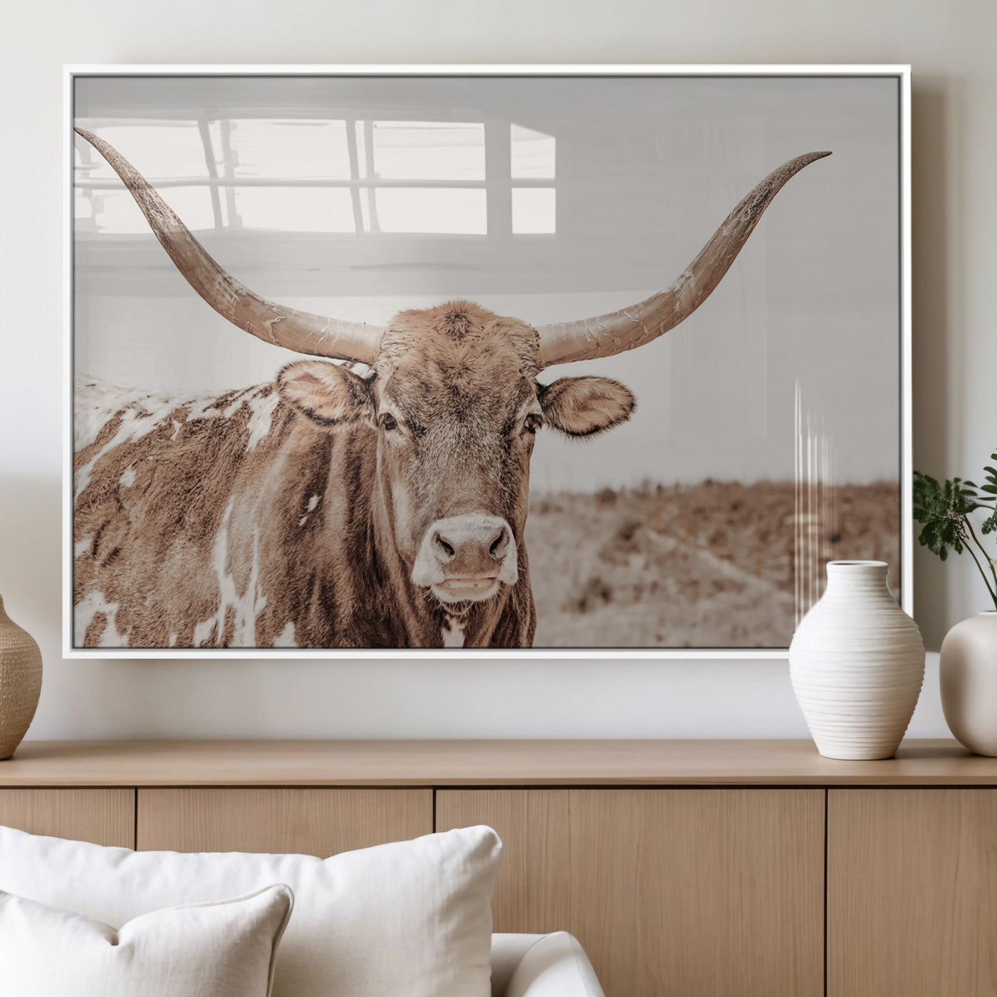 A longhorn cow in soft beige desert tones, standing calmly in open land, perfect for neutral western or rustic farmhouse interiors.