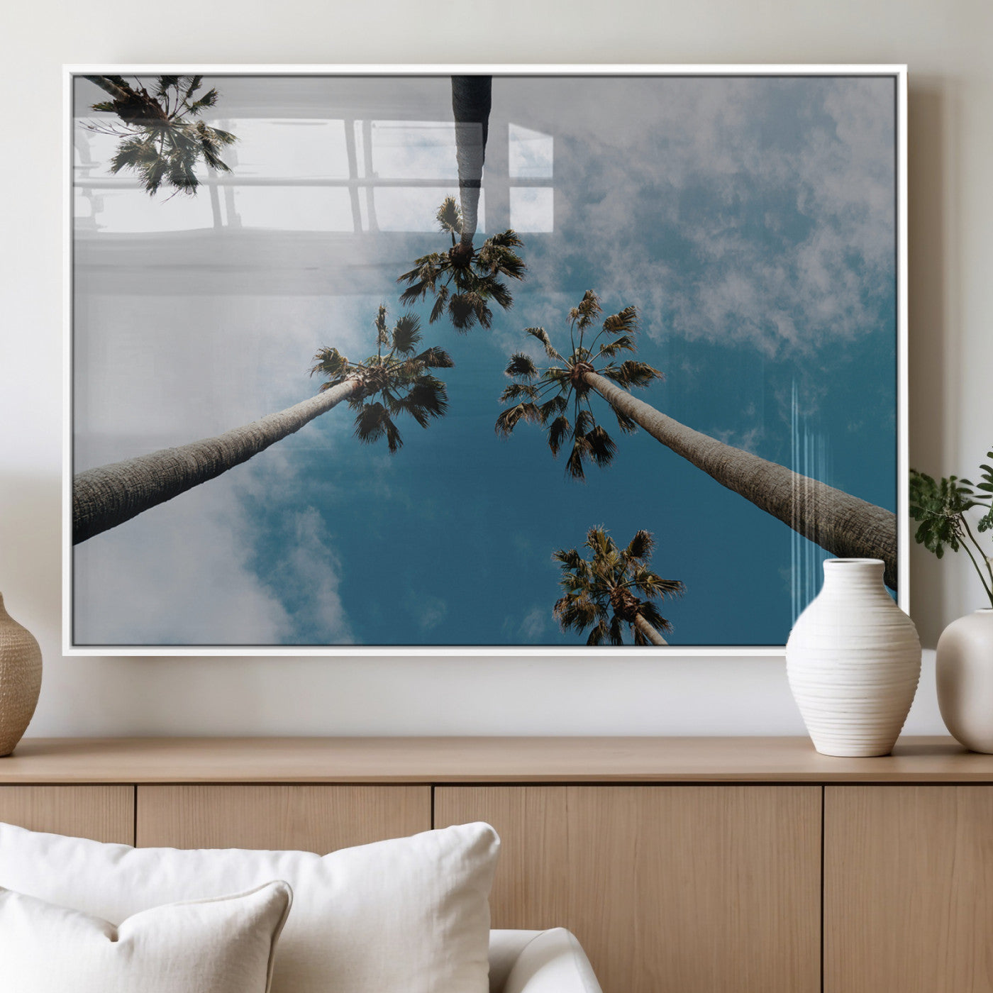 Looking up at tall palm trees against a bright blue sky with scattered clouds, creating a tropical and airy atmosphere for modern home decor.