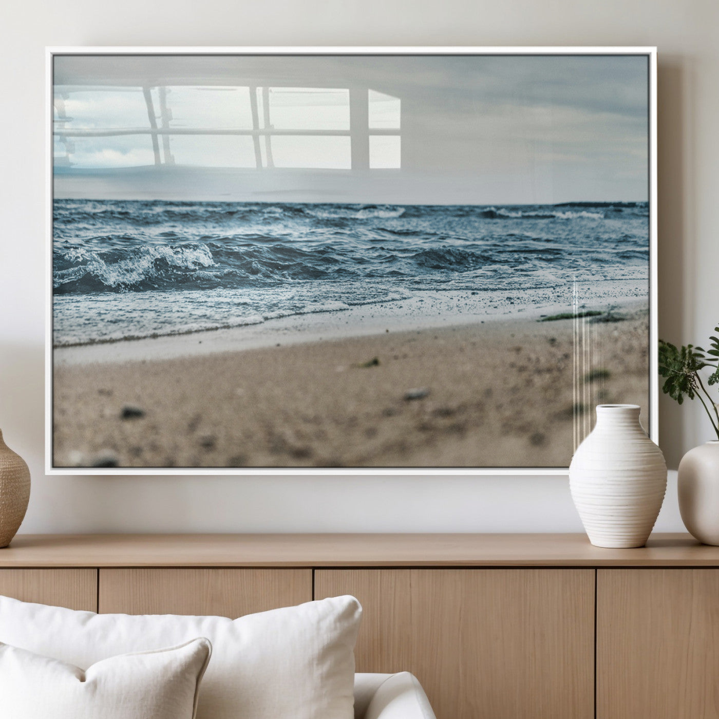 A moody ocean scene with gentle waves washing onto a sandy beach under a cloudy sky, creating a peaceful and coastal atmosphere.