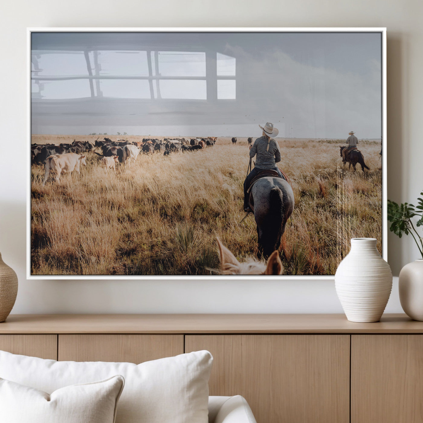 A cowboy and cowgirl on horseback herding cattle through golden grasslands, capturing a rustic and authentic Western ranch lifestyle.