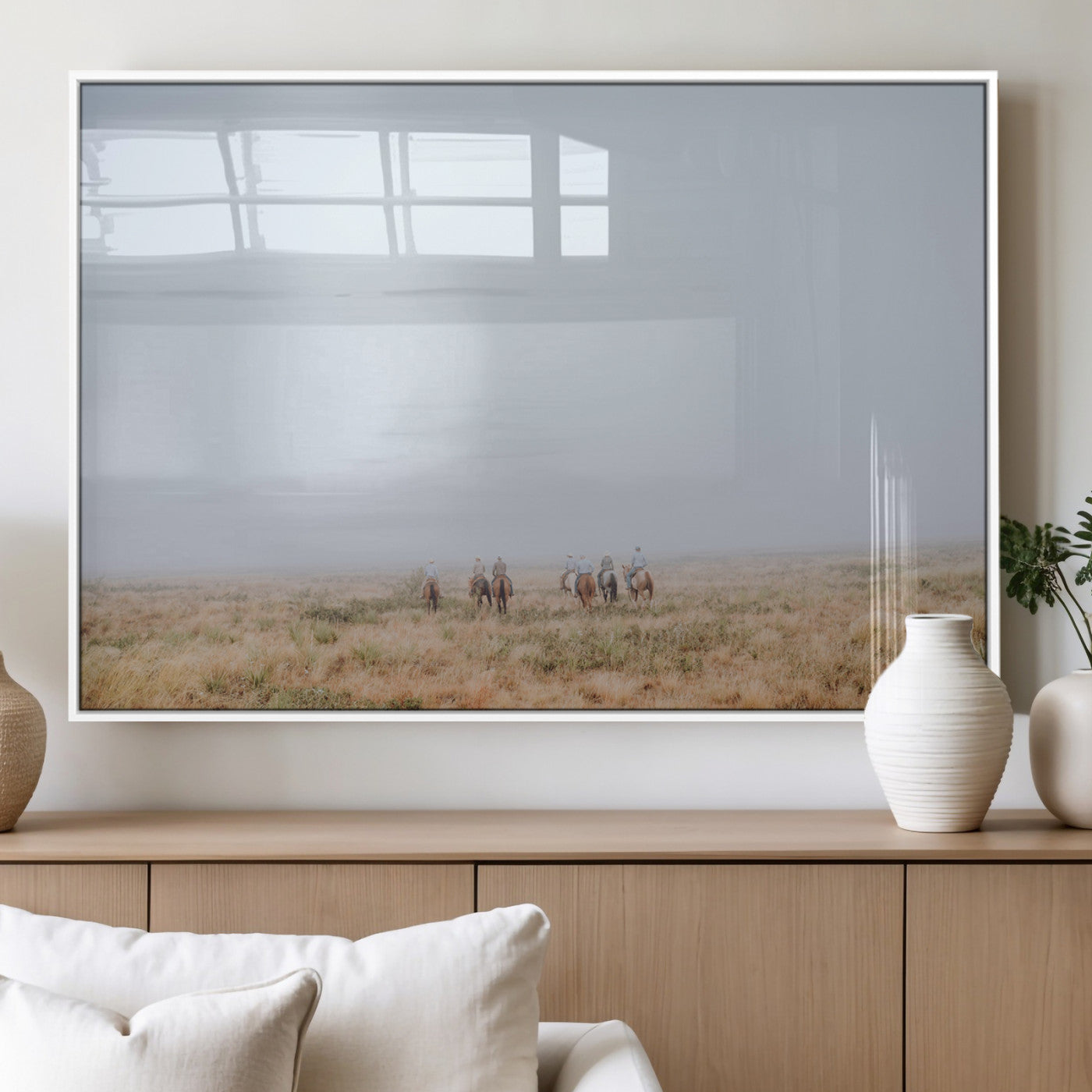 A group of horseback riders moving through a fog-shrouded field, evoking a calm Western scene with golden grasses and soft horizons.