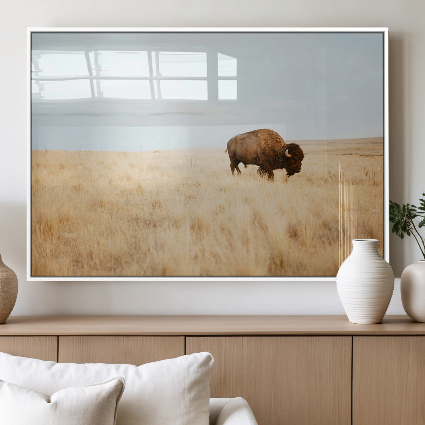 A lone bison standing in a vast golden grassland under a soft blue sky, evoking a rustic and Western aesthetic, ideal for farmhouse decor.
