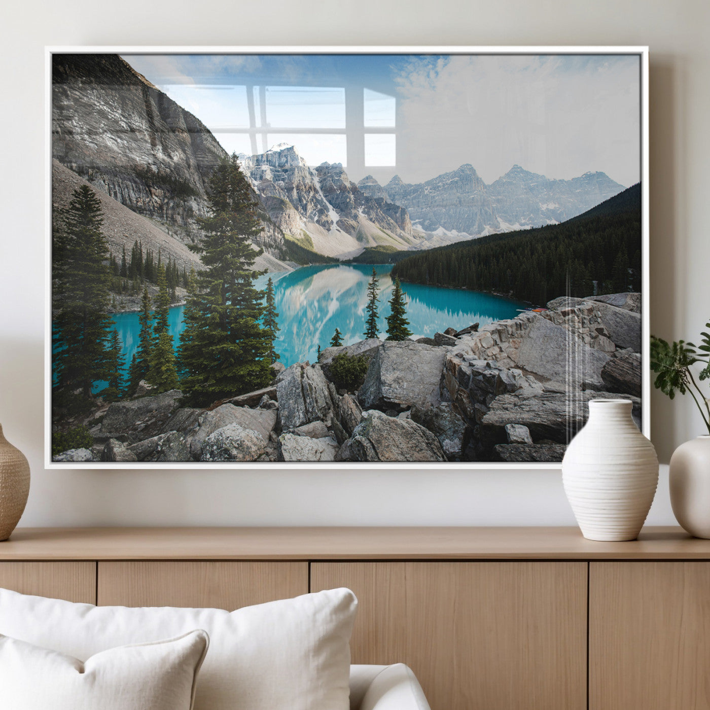 Stunning view of Moraine Lake with turquoise waters reflecting snow-capped mountains and evergreen trees, creating a peaceful alpine decor.