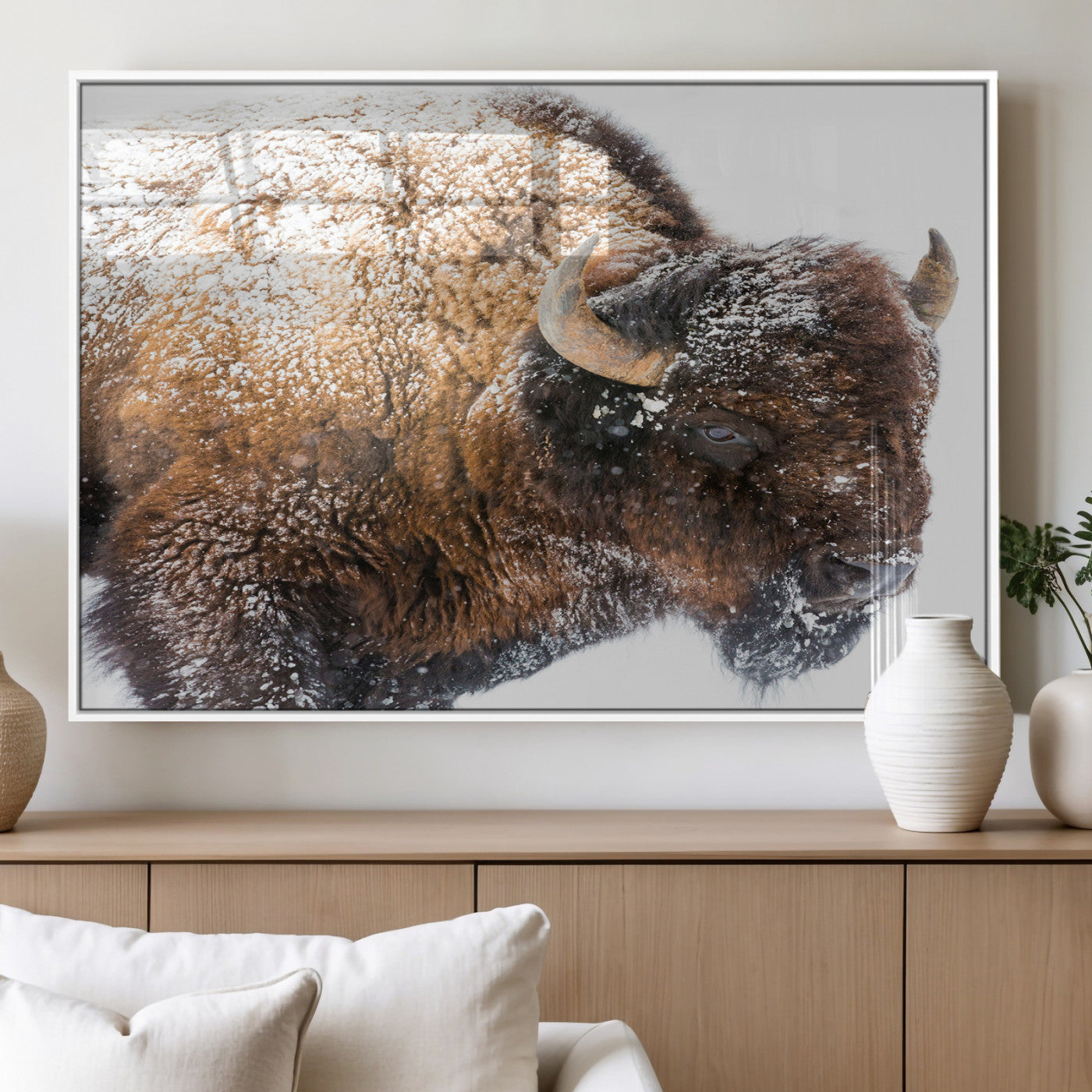 Close-up photograph of a bison covered in snow, highlighting its thick fur and powerful presence, set against a white winter backdrop, ideal for rustic decor.