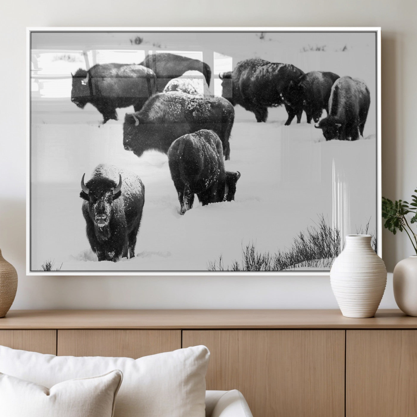 Black and white photograph of a bison herd in a snowy landscape, with snow-covered fur and a rugged wilderness setting, perfect for rustic lodge decor.