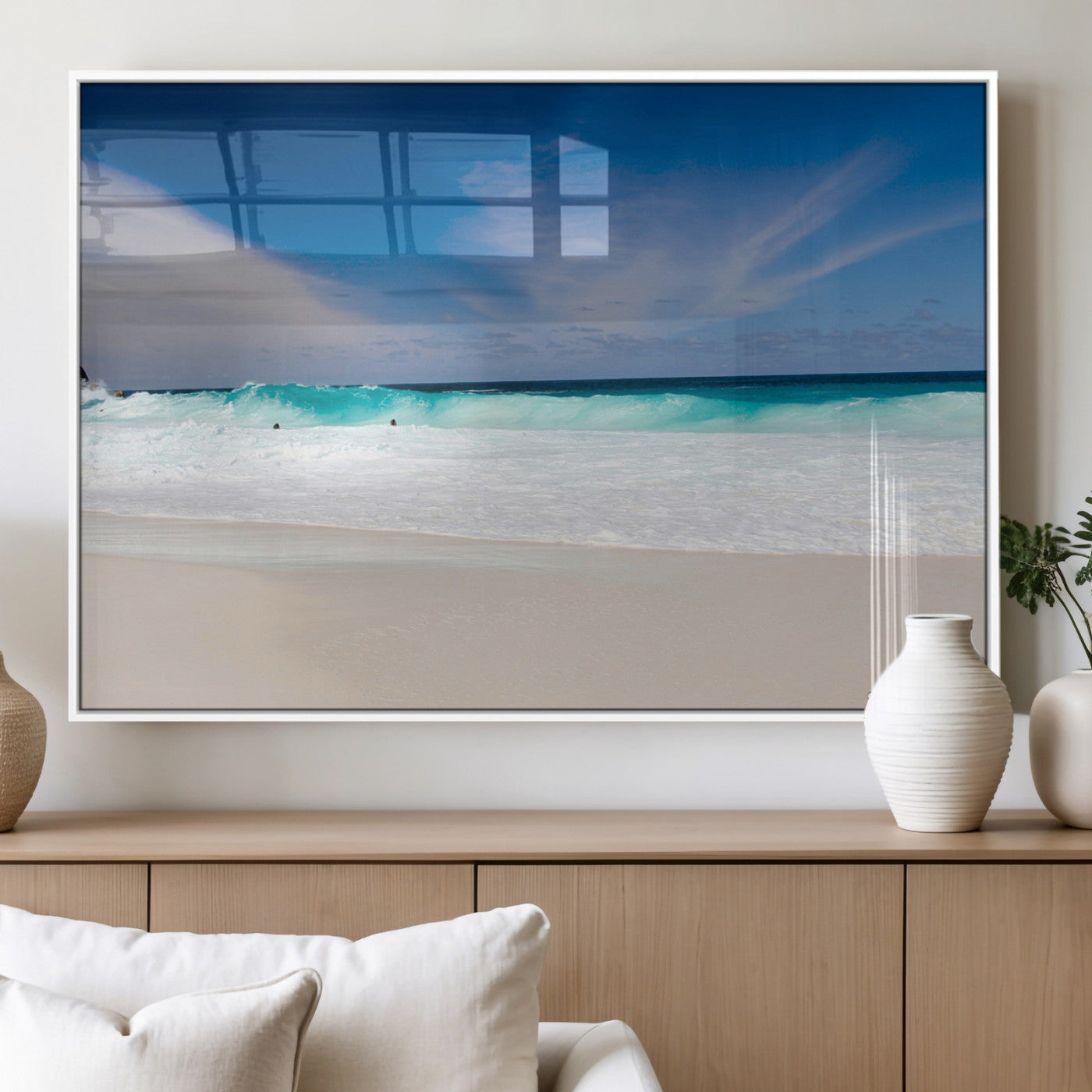 Turquoise waves crash onto a pristine white sand beach under a vivid blue sky with wispy clouds, creating a peaceful and refreshing coastal scene.