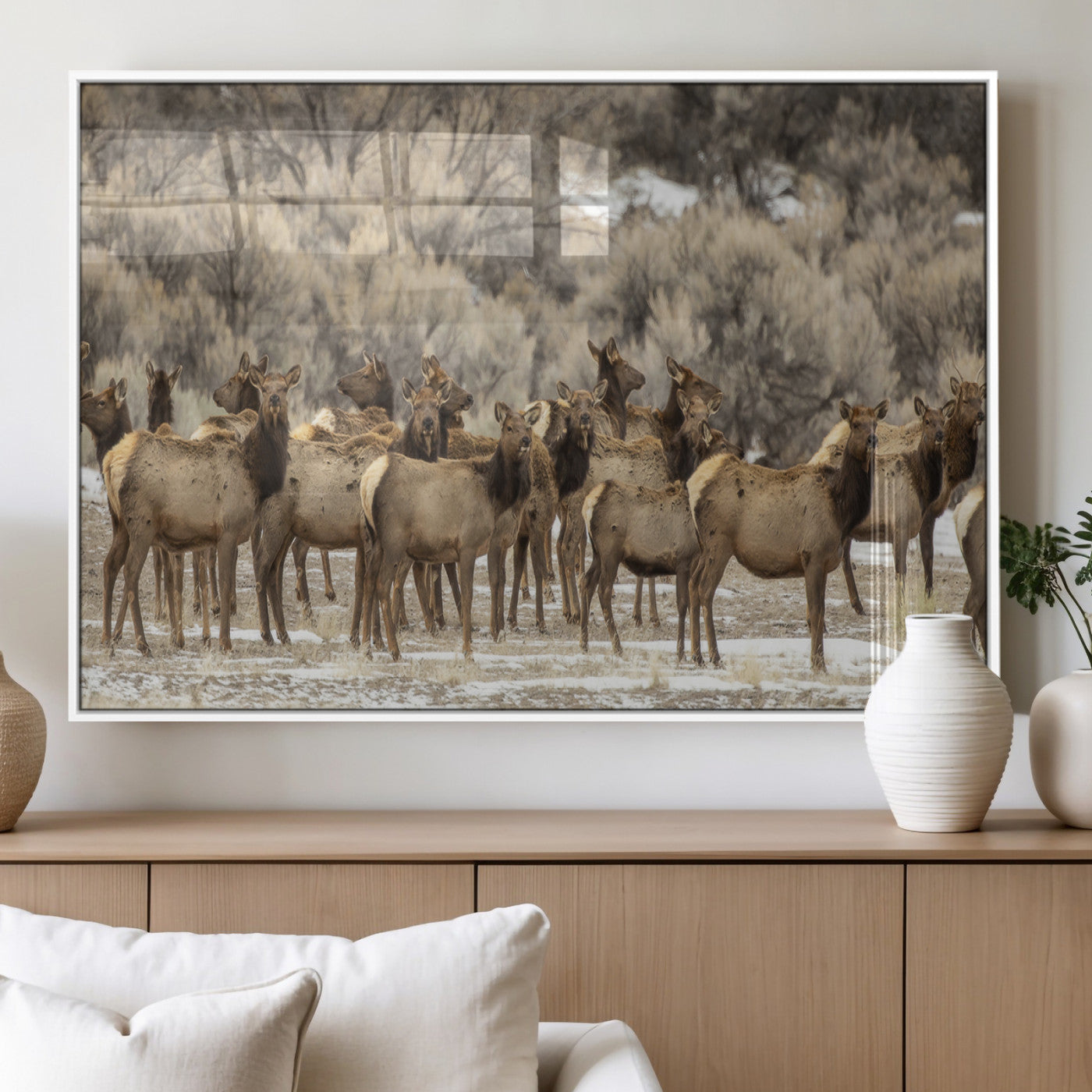 A stunning wall art canvas print featuring a large herd of elk standing together in a natural winter landscape with muted earthy tones and soft background foliage, perfect for rustic or nature-inspired home decor.